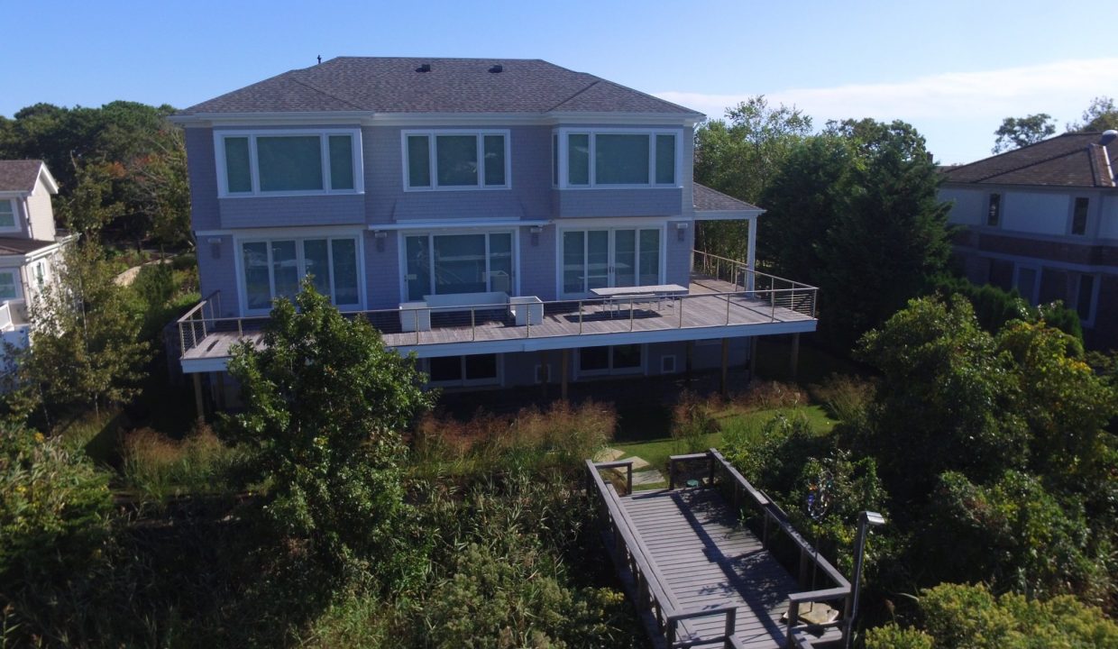 Large home with a wrap around deck and a dock